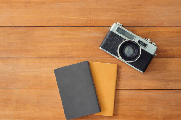 istock Minimal work space - Creative flat lay photo of workspace desk. Office desk wooden table background with mock up notebooks and retro camera. Top view with copy space, flat lay photography 964283042