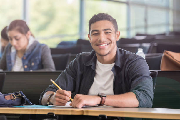 istock Handsome young man smiles proudly in college classroom 964283730