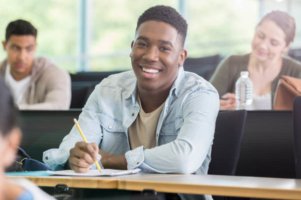 istock Handsome young man smiles for camera in college lecture hall 964283750