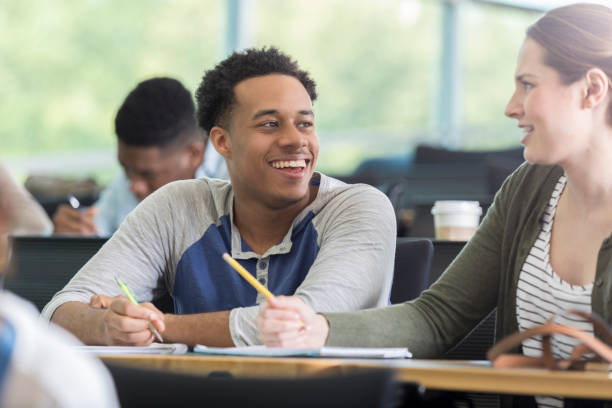 istock Young man enjoys humorous discussion with college classmate 964283756
