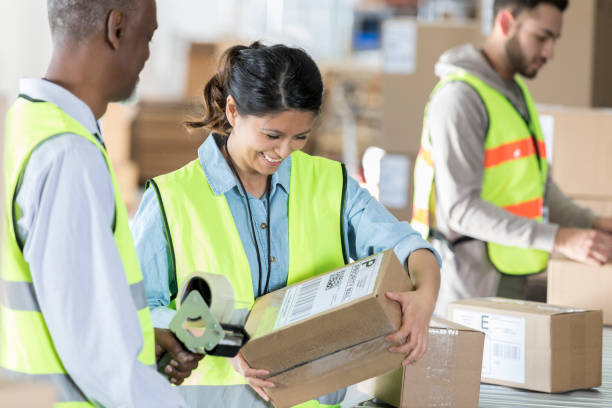 distribution warehouse workers seal packages - post processing imagens e fotografias de stock