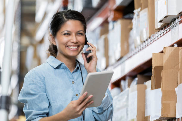 istock Friendly distribution warehouse employee uses smart phone 964286752