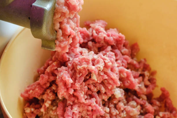 istock Close up meat grinder or mincing-machine with mincemeat in. Showing the forcemeat process. 964287474