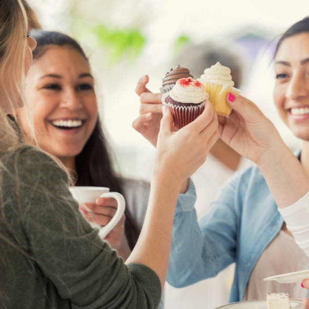 istock Women 'toast' cupcake during bake sale 964288378