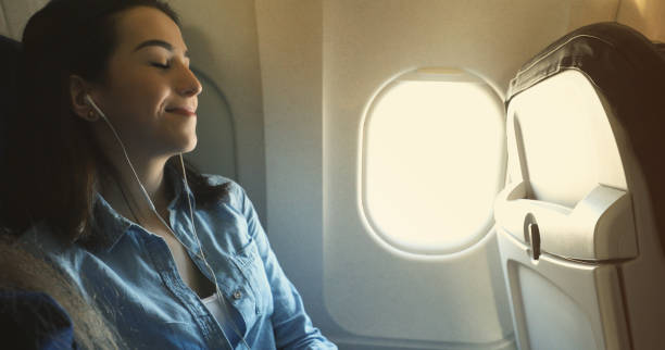 istock Woman relaxes while flight on commercial airplane 964288684