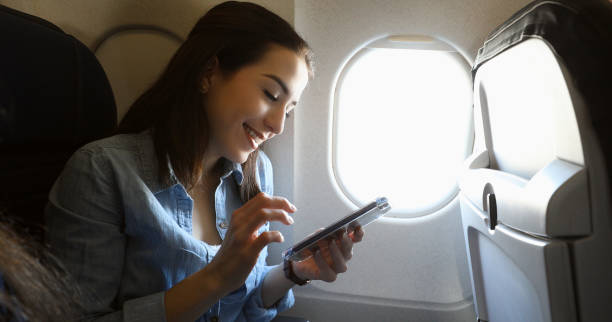 istock Woman uses smart phone while on plane 964288690