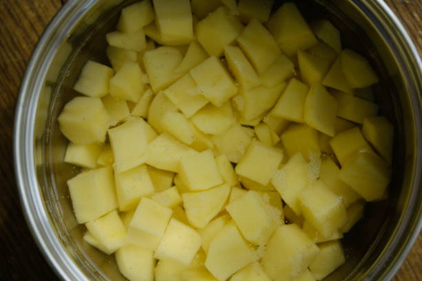 istock Sliced potatoes in water in a metal bowl 964292084