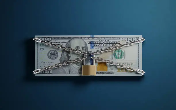 Vector illustration of One Hundred American Dollar Banknote Tied With A Padlock And Chain One Blue Background