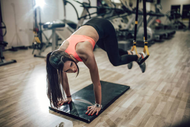 istock Woman workout on suspension straps in gym 964296720