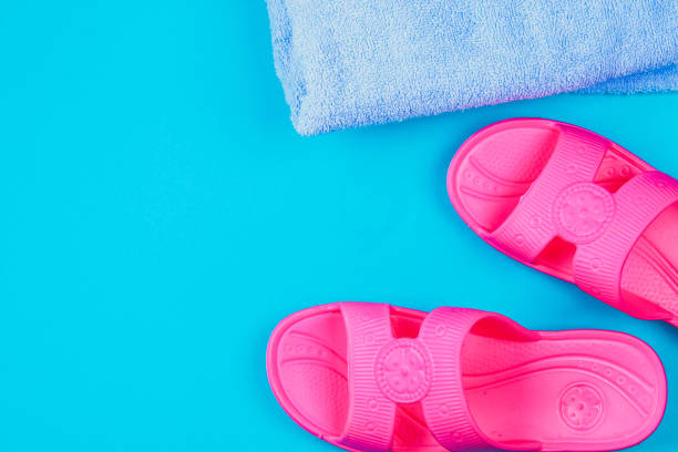 istock Slippers, towel on a blue pastel background. Rest, travel. Top view. Copy space. Flat lay. 964300394