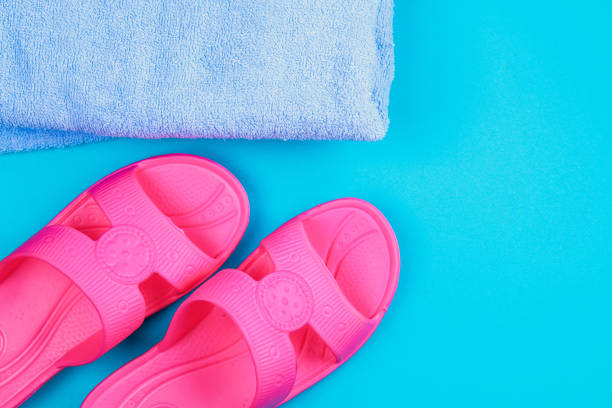 istock Slippers, towel on a blue pastel background. Rest, travel. Top view. Copy space. Flat lay. 964300426