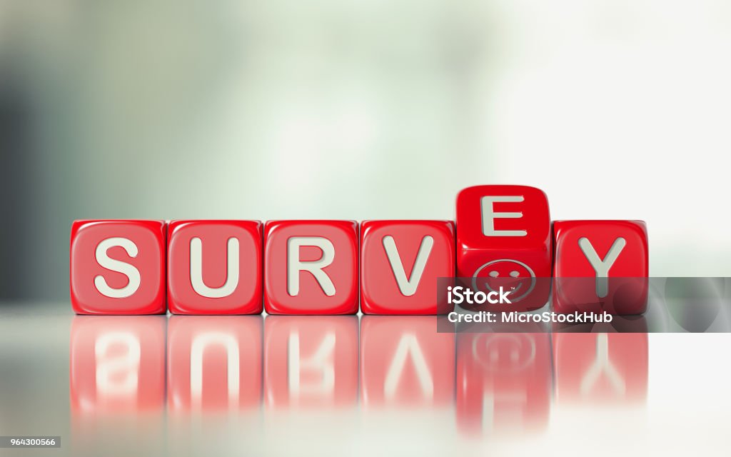 Survey Concept - Red Dices With Survey Text And A Smiley Face Red toy blocks are rotating  on white reflective surface  over pale defocused background.  Survey writes on the cubes with a smiley face. Survey concept. Horizontal composition with copy space. Questionnaire Stock Photo