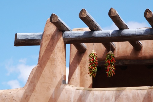 Chili peppers hanging on adobe building photo
