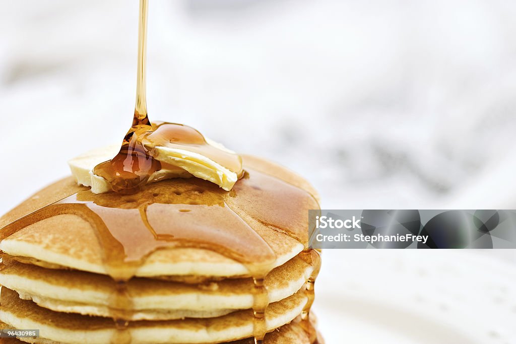 Pancakes Maple syrup pouring onto pancakes. Shallow DOF with focus on syrup and butter.  Pancake Stock Photo