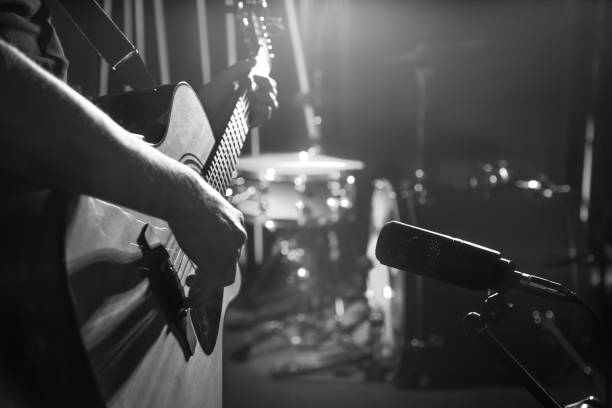 istock The Studio microphone records an acoustic guitar close-up. Beautiful blurred background of colored lanterns. 964318286