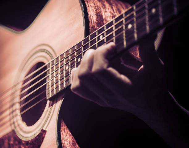 istock Man playing acoustic guitar on dark background. A musical concept. 964318334