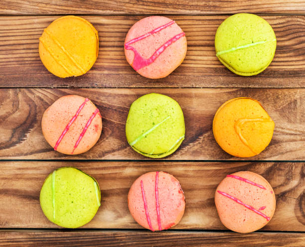 istock Rows of colorful macaroons on wooden background. Top view. 964318802