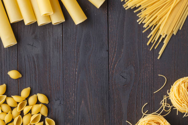 istock Raw pasta on rustic dark wooden background 964318966