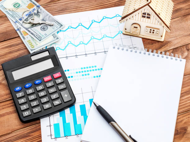 istock Blank notepad with business graphs, model of house, calculator and money at workplace. 964320314
