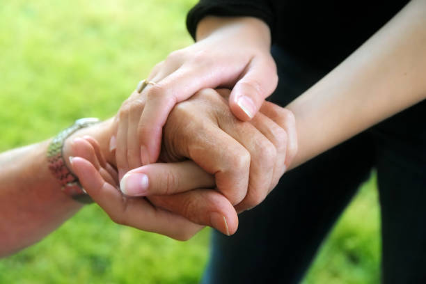 istock young women's hands hold the hand of a elderly 964325130