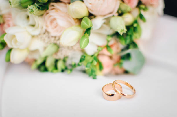 istock Wedding rings against flowers 964326072
