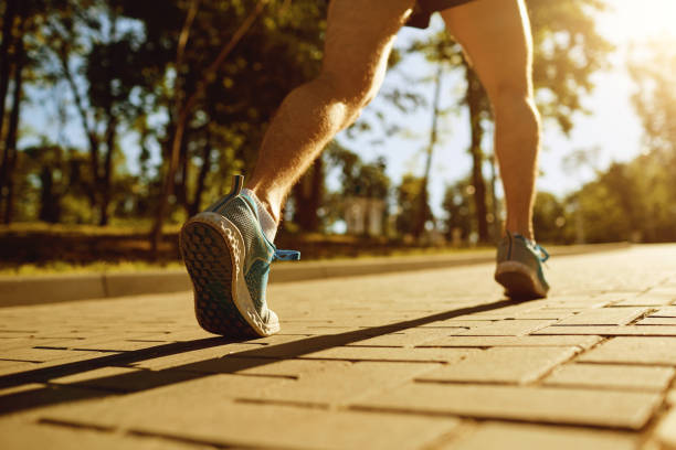 istock Legs runner on the track park at sunset 964328370