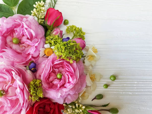 istock roses chamomile bouquet on white wooden background 964338144
