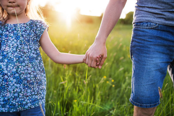 istock Father with a small daughter on a walk in spring nature at sunset. 964344240