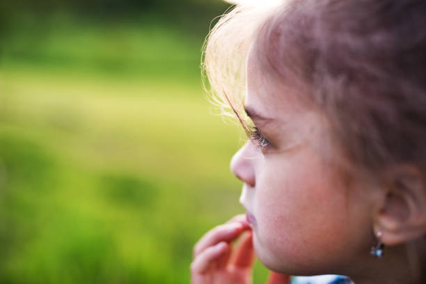 A portrait of a small girl in the garden in spring nature. Copy space. Close up.