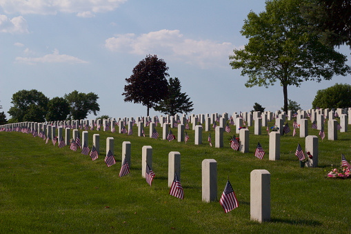 This image shows American flags decorating the tombstones of soldiers' graves in a national cemetery.