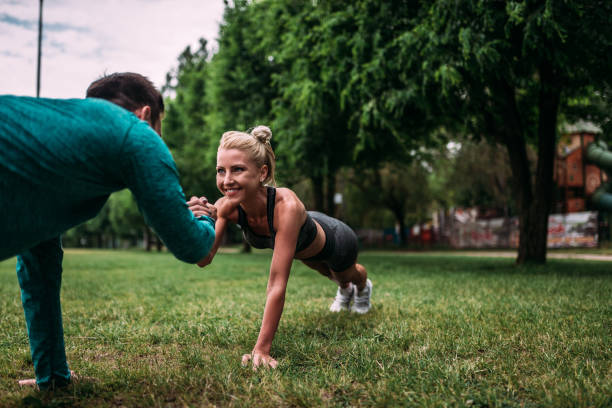istock Couple doing push-ups outdoors. 964372080