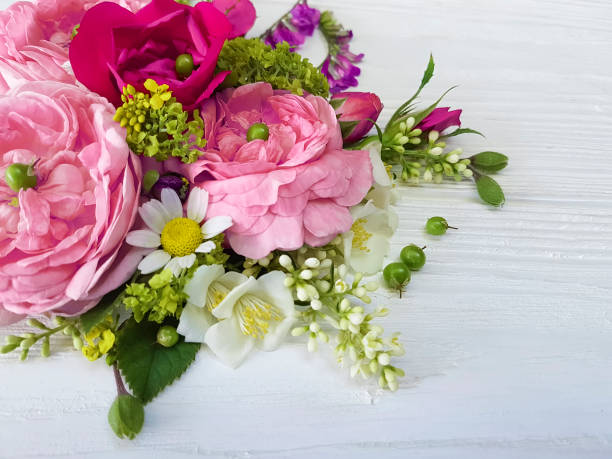 istock roses chamomile beautiful bouquet frame on a white wooden background 964372158