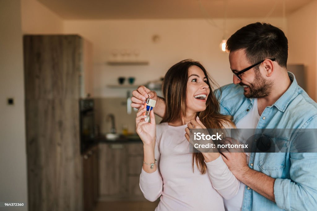 Giovane che sorprende sua moglie o una ragazza con un nuovo appartamento. - Foto stock royalty-free di Famiglia