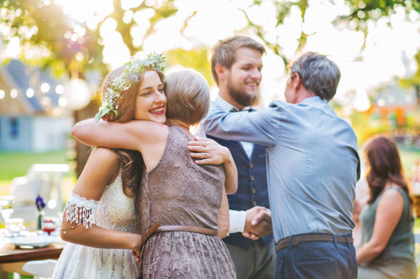 Guests congratulating bride and groom at wedding reception outside in the backyard. Guests congratulating happy bride and groom at wedding reception outside in the backyard. bride hugging father on wedding day stock pictures, royalty-free photos & images