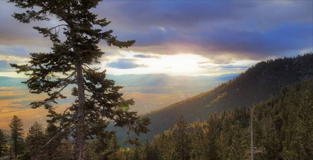 istock Sun rays beaming down from the sky onto a valley below a mountain forest. 964381262