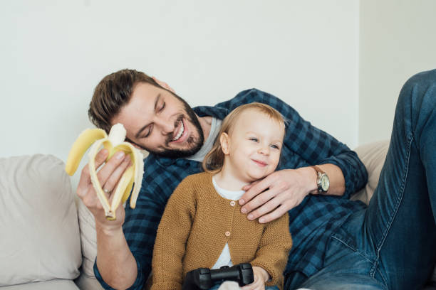 istock Happy father holding banana and hugging daughter 964384308