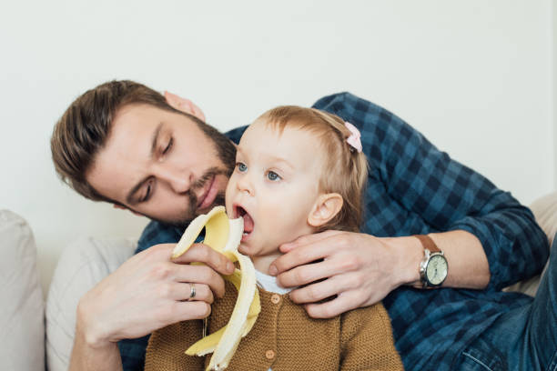 istock Father feeding banana to daughter 964384368