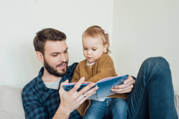 istock Father reading a book to his daughter 964384736