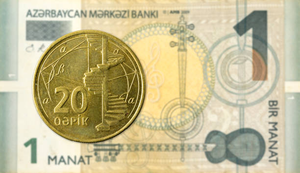 20 azerbaijani qepik coin against 1 azerbaijani manat bank note stock photo