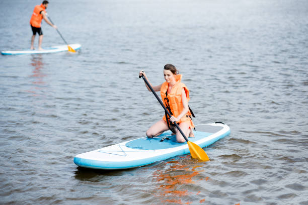 istock Couple rowing on the stand up paddleboard 964392078