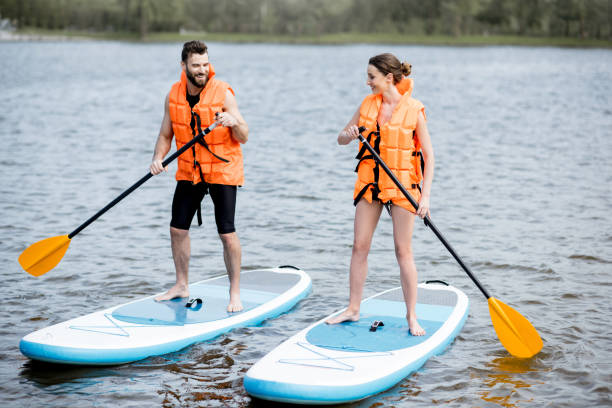 istock Couple rowing on the stand up paddleboard 964392196