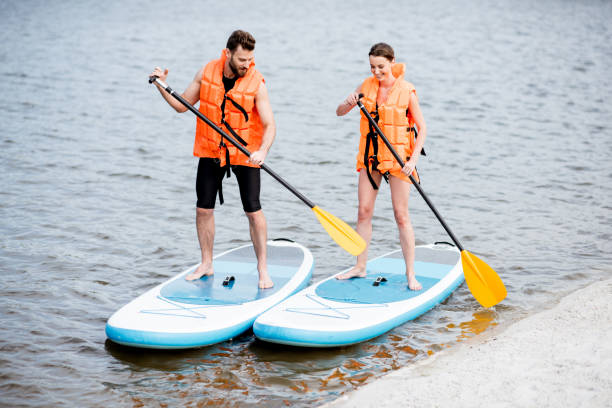 istock Couple rowing on the stand up paddleboard 964392282