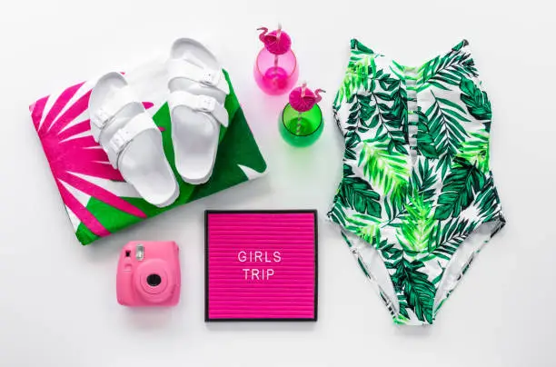 Tropical Beach Themed Flat Lay with Girls Trip Letter Board Quote, Drinks, Pink Camera, Trendy Summer Accessories