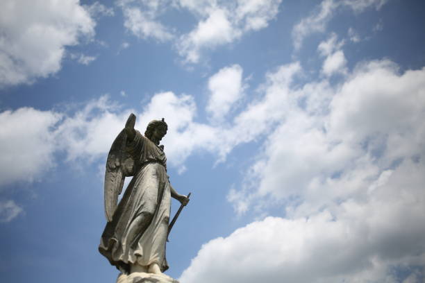 istock Christianity and Religious Iconography Angel Statue Figurine in a Graveyard 964399146