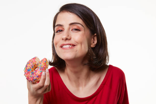 istock young woman eating a donut 964406964