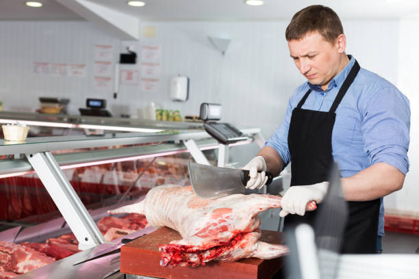 istock butcher cutting lamb carcass in butcher shop 964413838