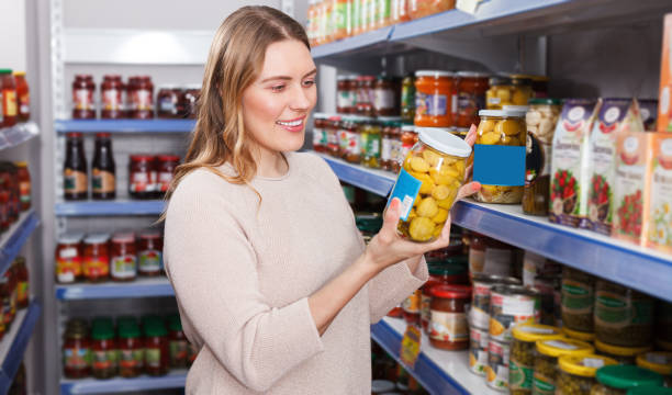 istock Cheerful female customer choosing pickle goods in the  store 964420028