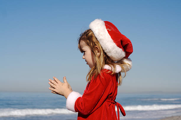 kleine santa mädchen am strand-serie - child praying beach little girls stock-fotos und bilder