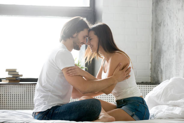 istock Loving happy couple embracing and laughing having fun on bed 964428964