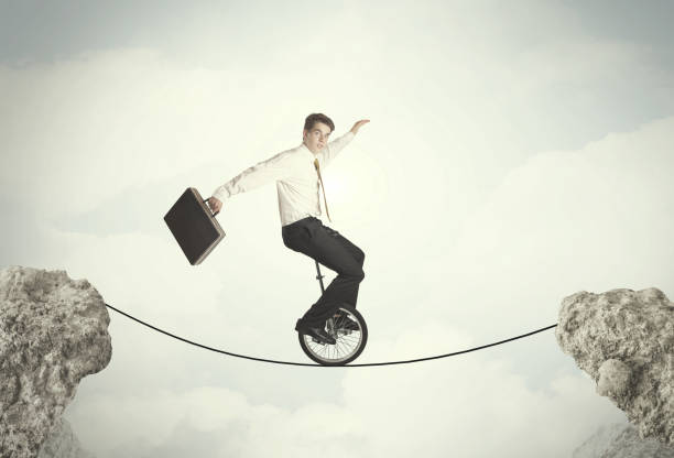 istock Brave business man riding an mono cycle between cliffs 964432030